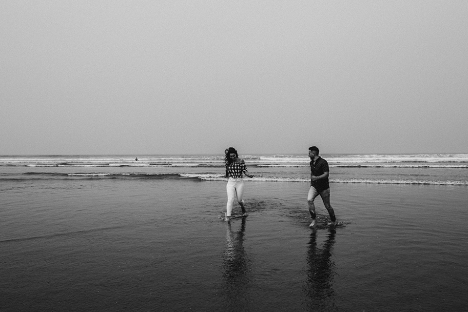 lovers running through the ocean waves in dude