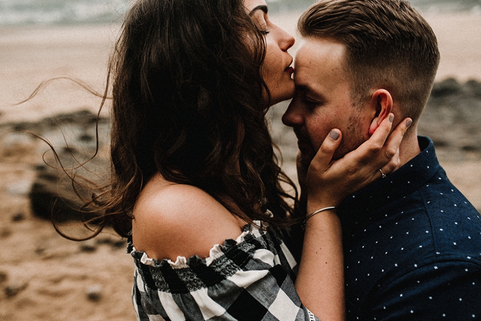 couple kissing , wind blowing her hair in dude