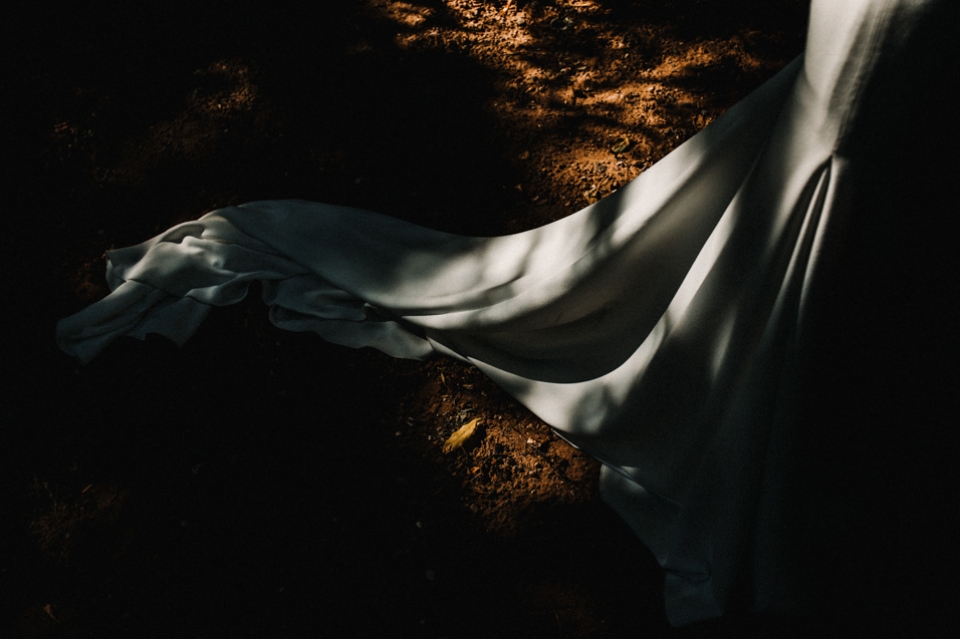 brides train catching a glimpse of the harsh sun light