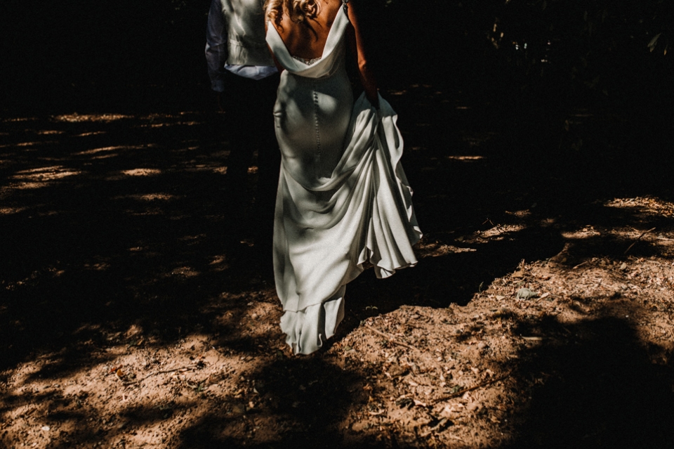 bride and groom walking into the forest 