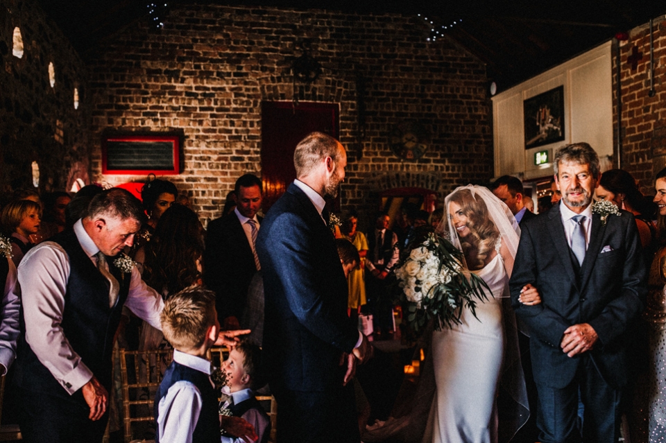 bride walking down the aisle at Riverdale barn