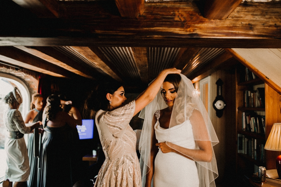 brides hairdresser adjusting her veil