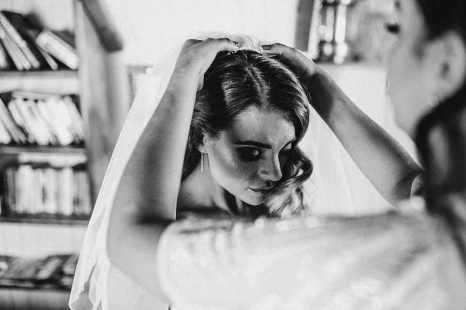 brides hairdresser putting her wedding veil in her hair