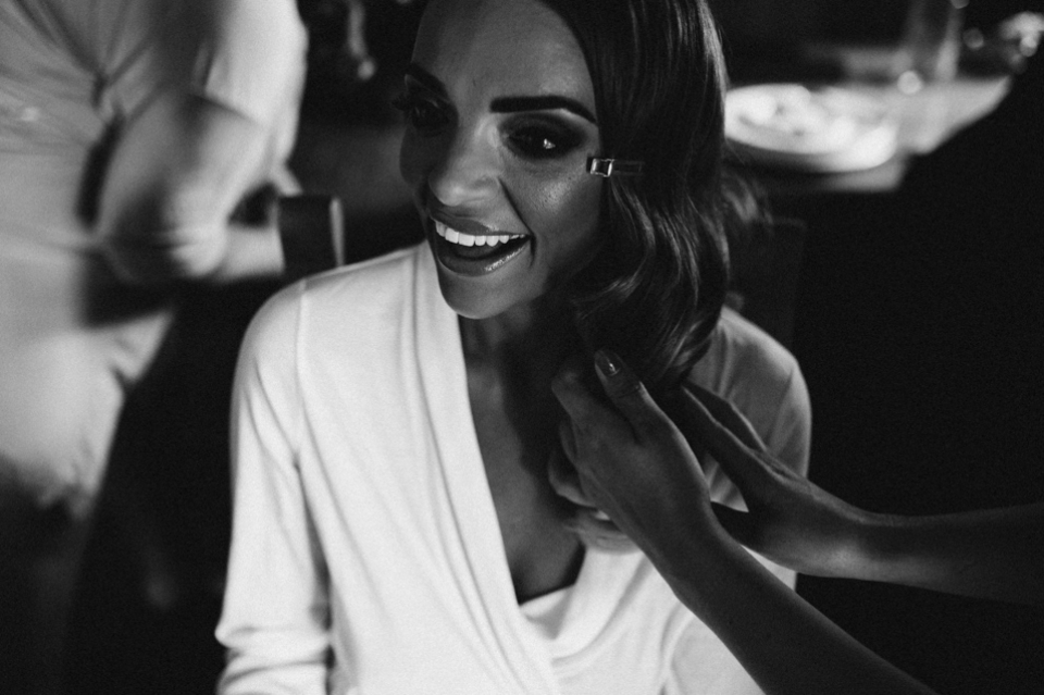 bride laughing as she is having her hair done 