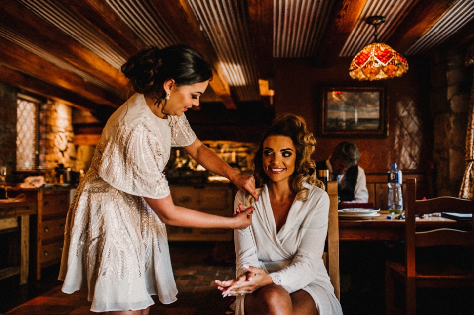 brides best friend doing final adjustments to her wedding hair 