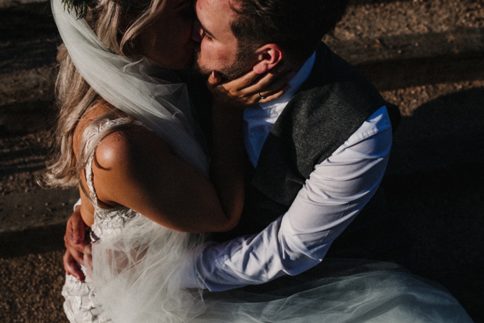 bride and groom kissing on the steps at the west mill wedding venue