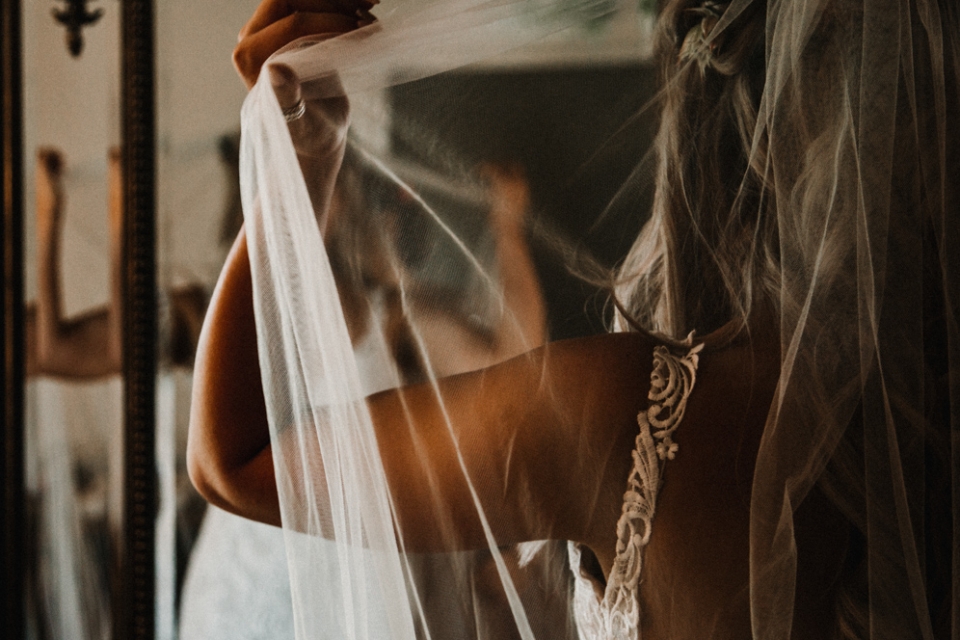 bride putting her veil on at the west mill