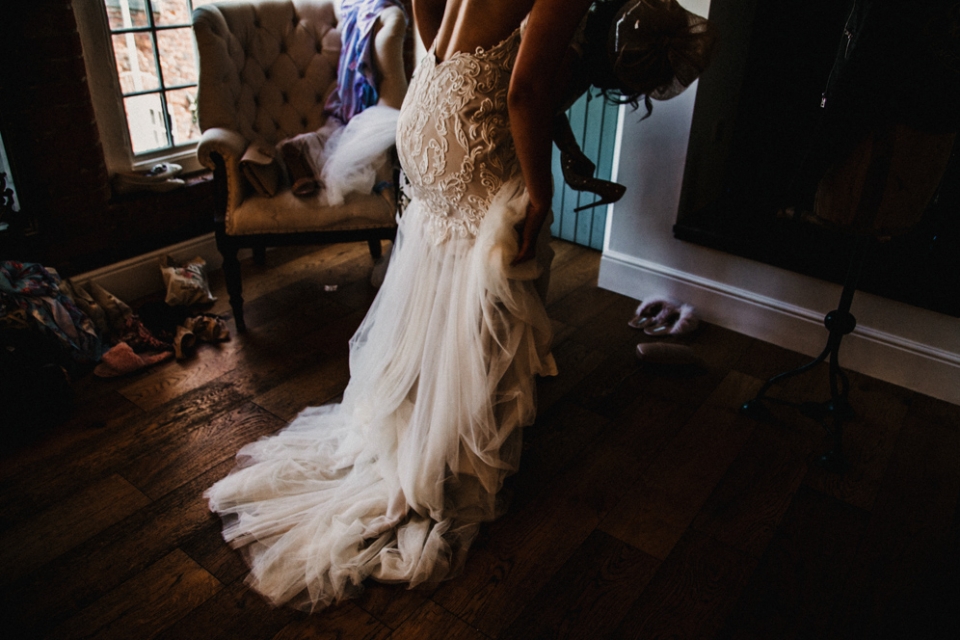 bride putting her dress on during bridal preparations