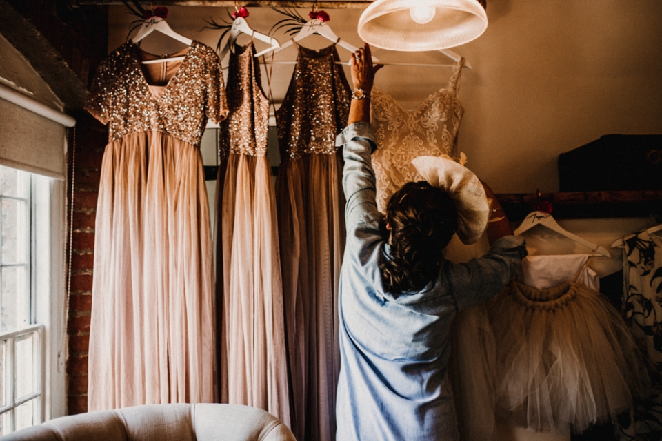 mother of bride reaching for brides dress