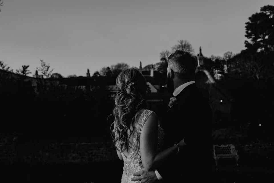 black and white portrait of bride and groom outside gardens in le petit chateau