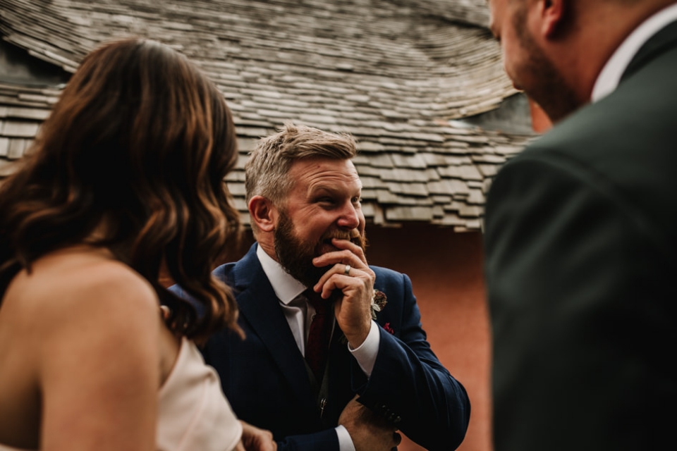 groom enjoying a giggle with friends during wedding reception