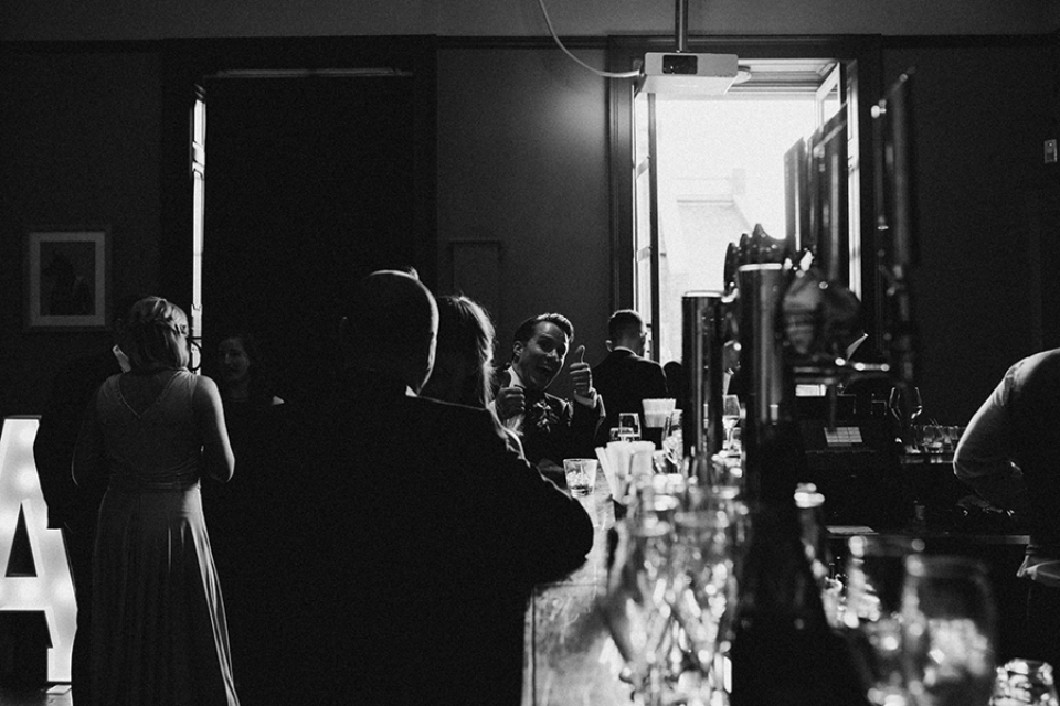 groom catching me taking a photograph of him at the bar in Oddfellows