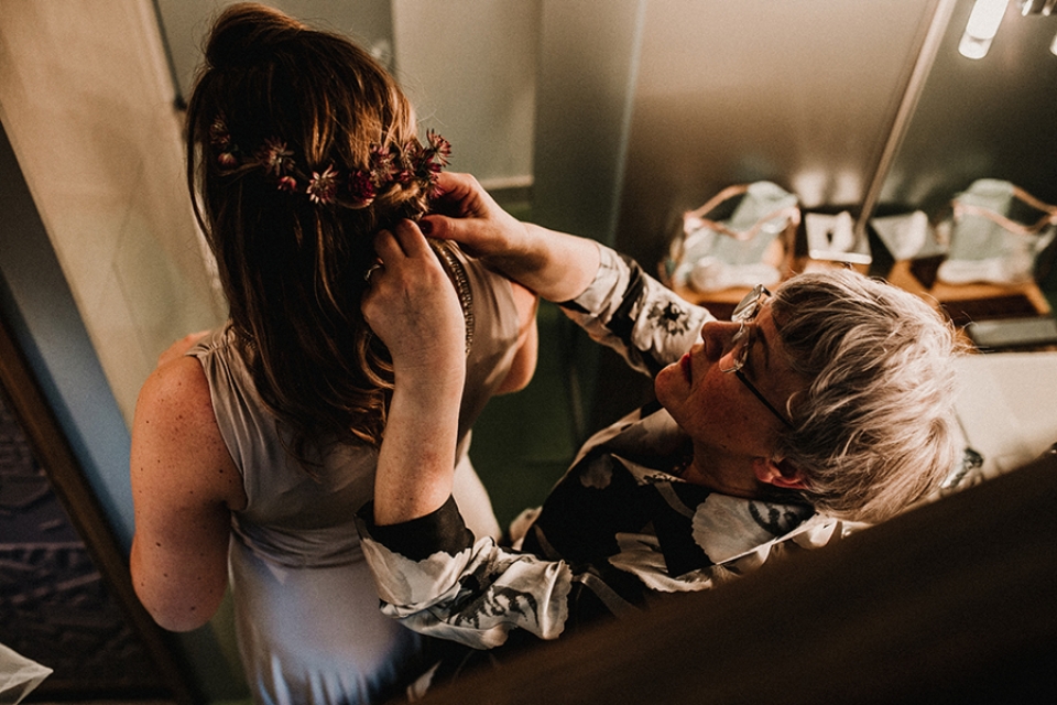 mother of brie helping bridesmaid with her hair