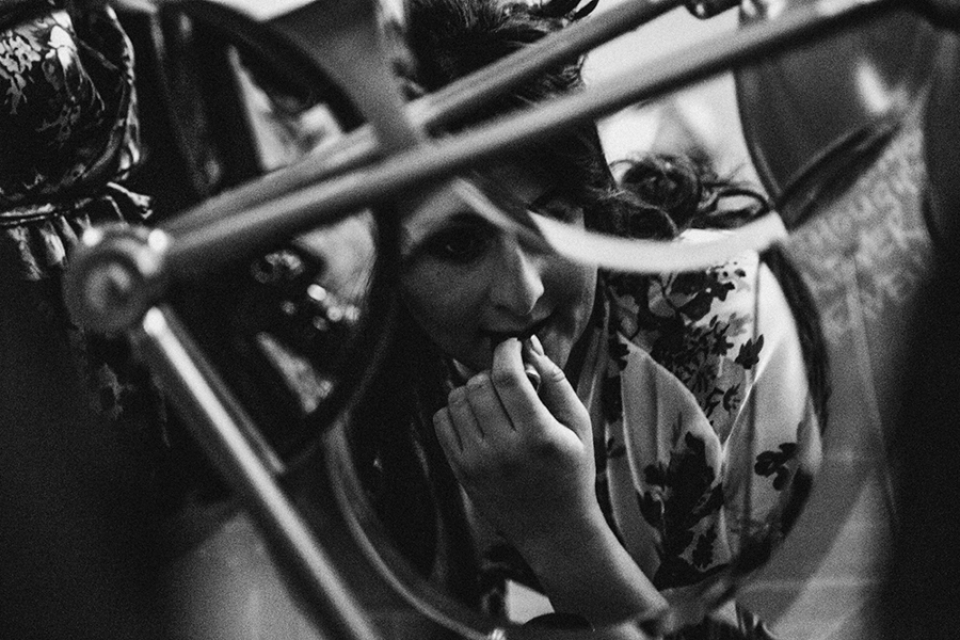 bridesmaid doing her lipstick in mirror