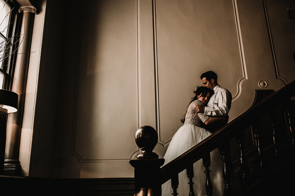 bride and groom cuddled up on the gran staircase