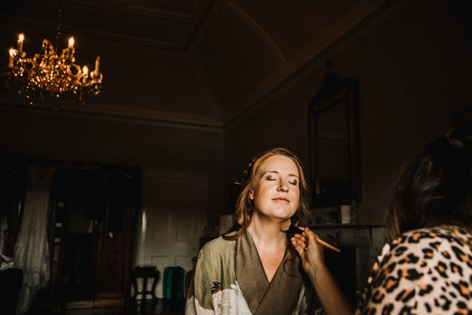 bride having her makeup and hair done during bridal prep