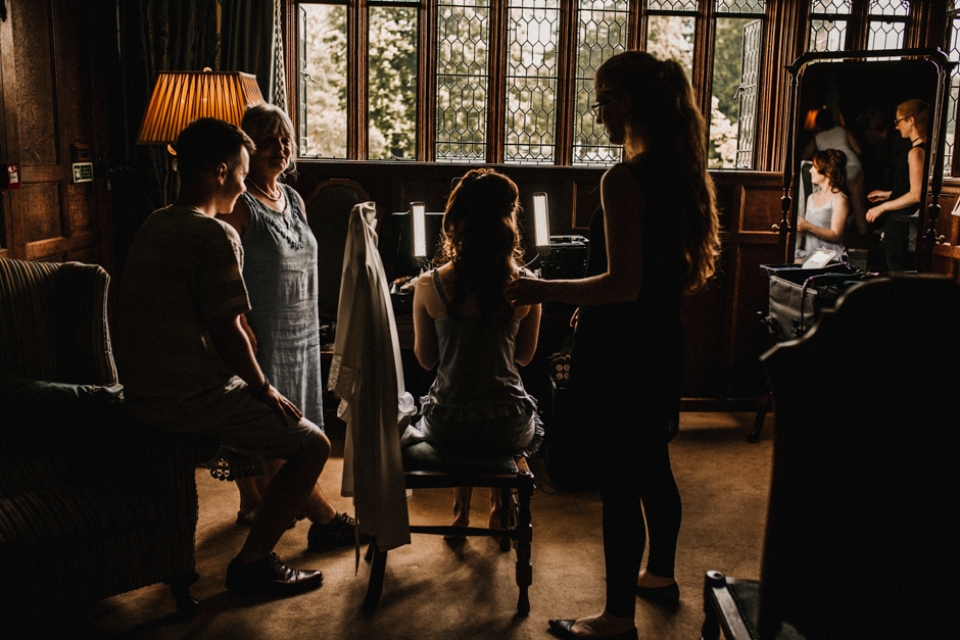 bridesmaids getting ready together with the bride at the castle , Kent