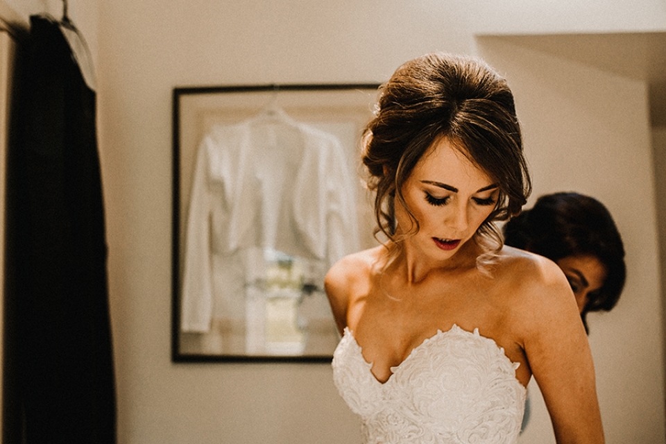 bride putting her dress on at the lodge