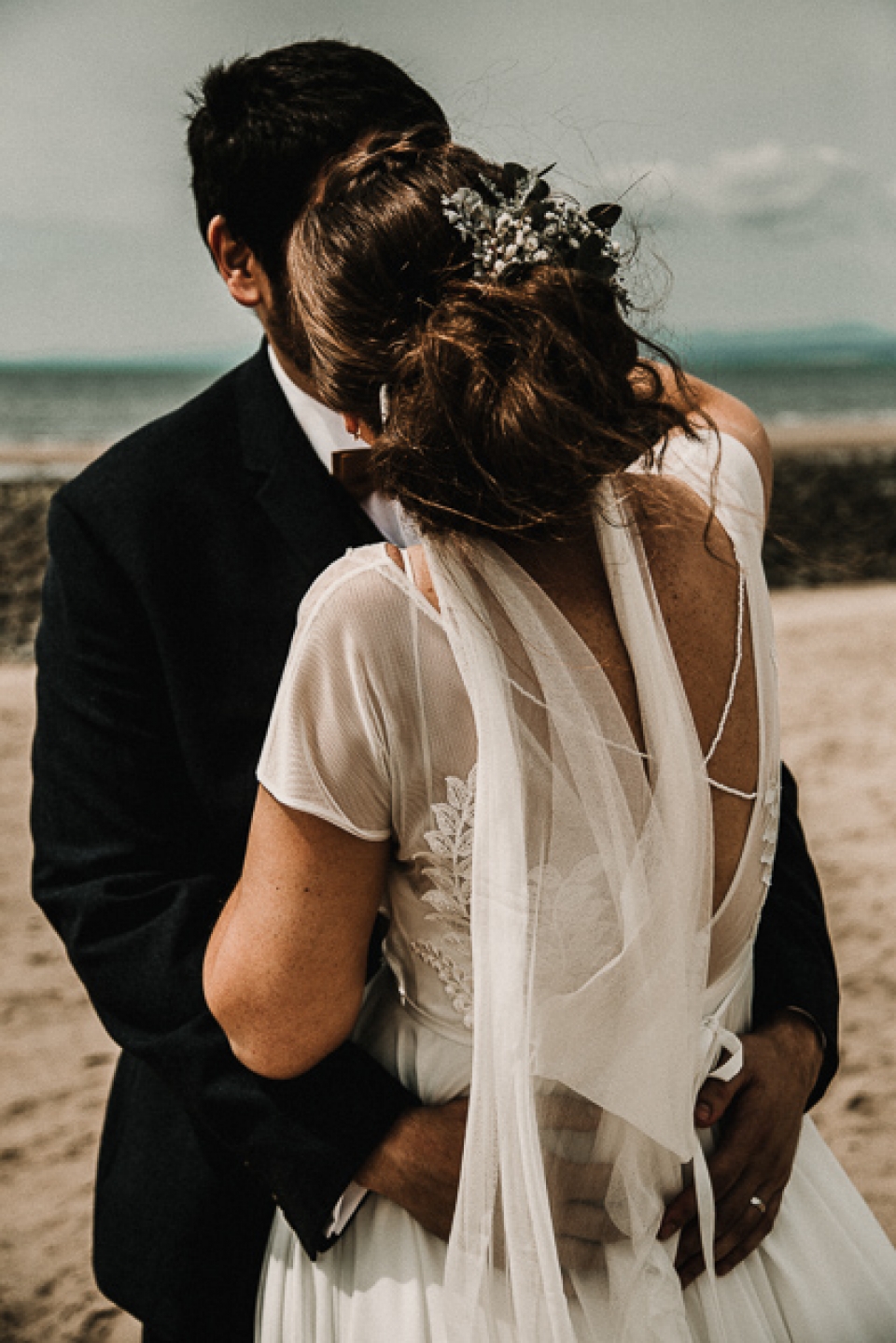 bride and groom kissing on the beach