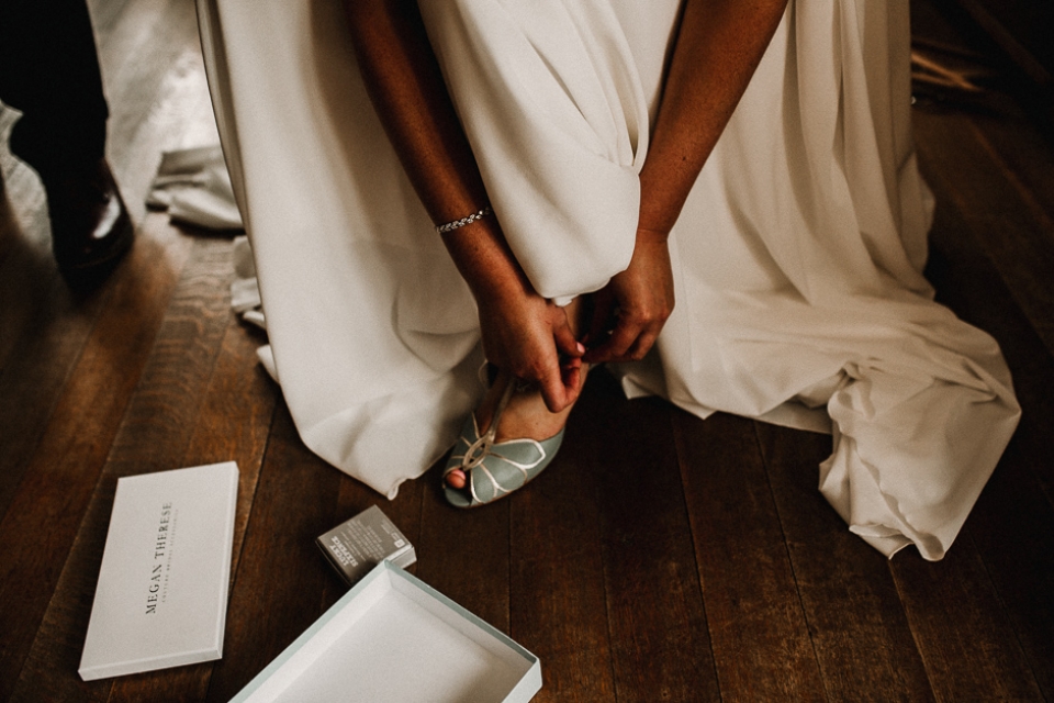 bride putting on her bridal shoes