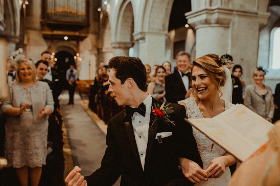 excited groom at the alter  as he says i do during the wedding vows