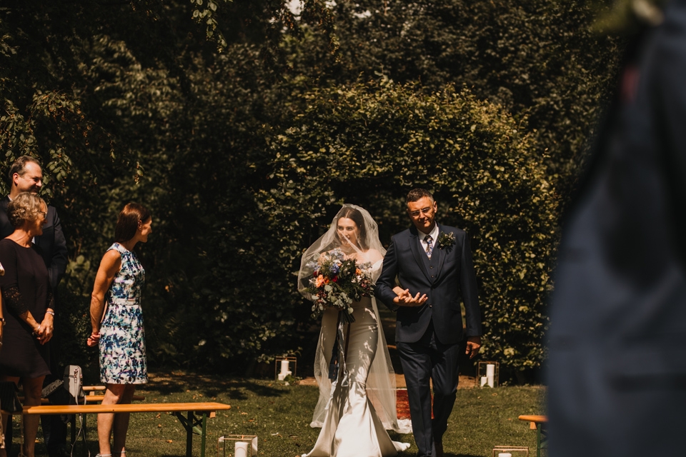 bride walking down the aisle at cripps barn walled garden