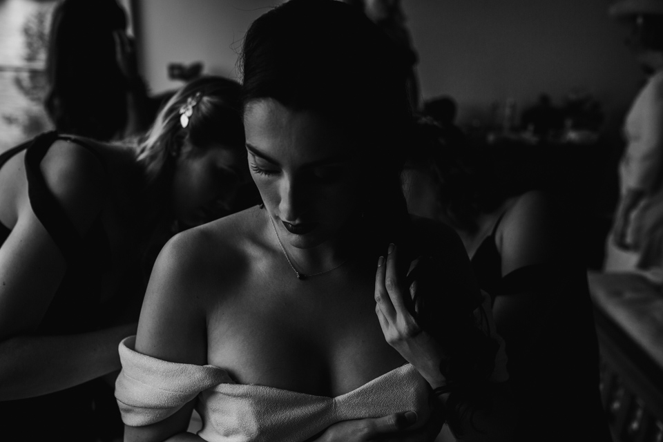 bridesmaids helping bride put her dress on in cotswolds 