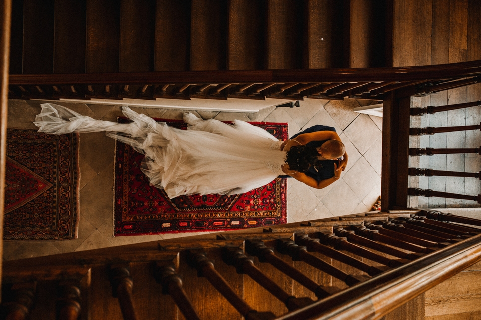 bride and groom kissing at the bottom of the stairs