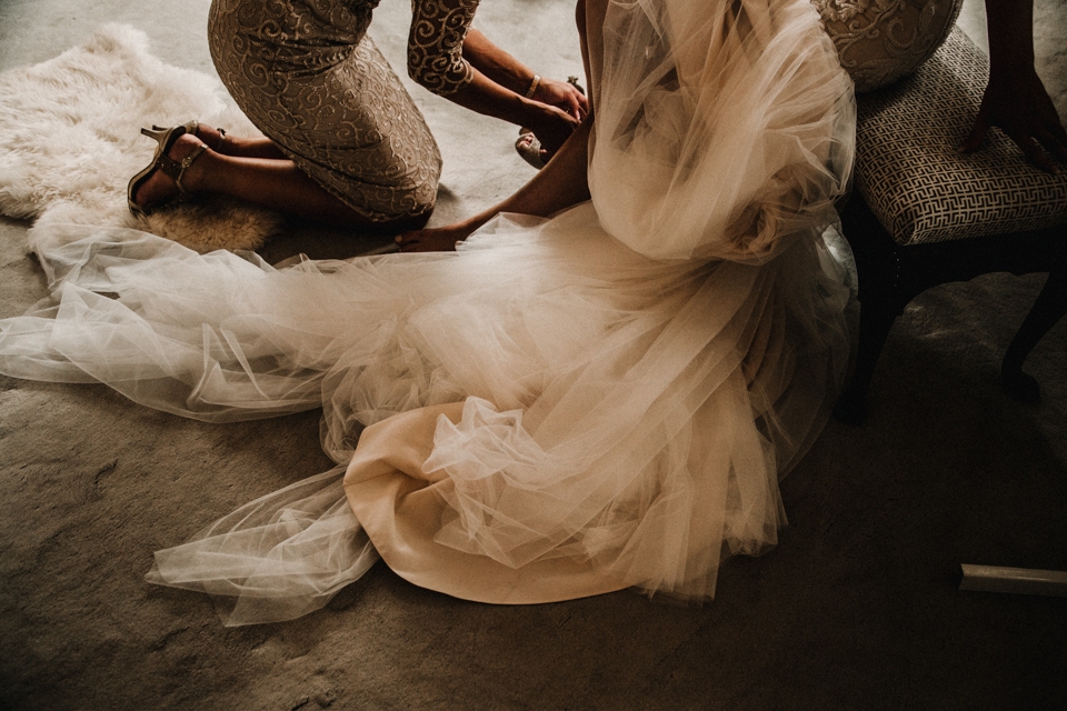 mother of the groom putting brides shoe on