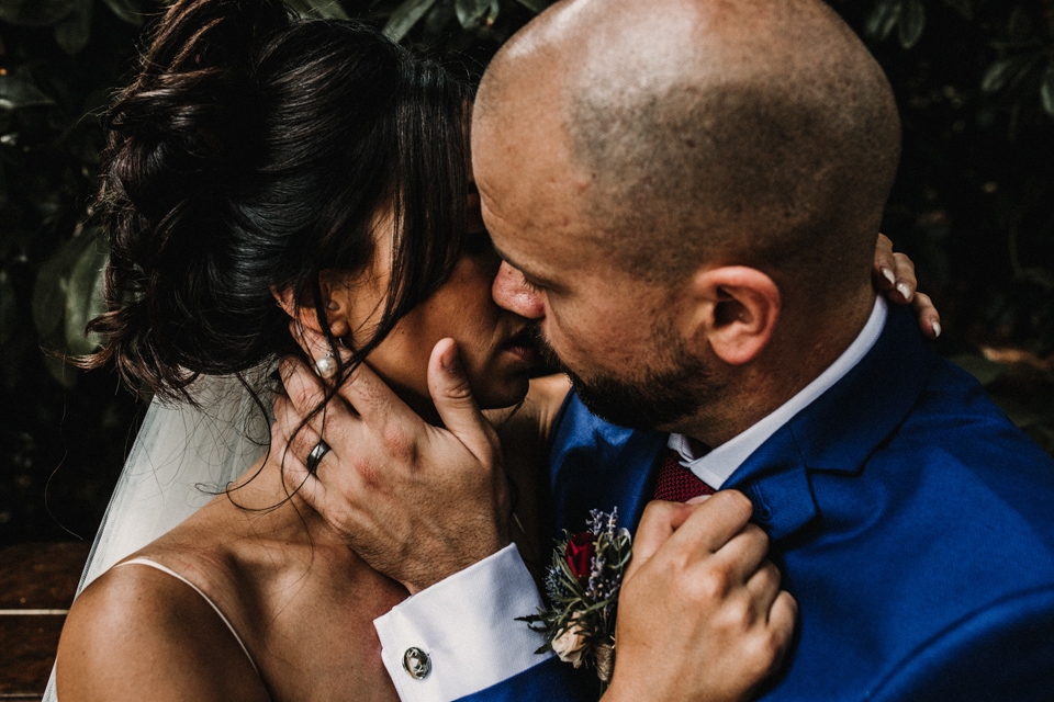 bride and groom kissing on the piano in the gardens