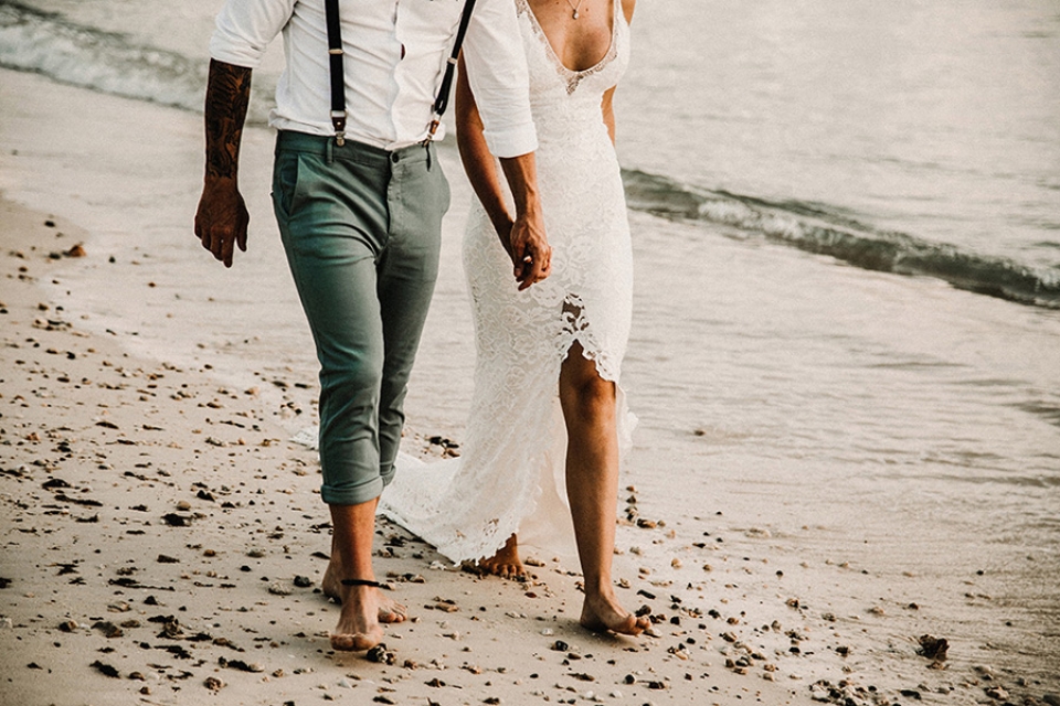 bride and groom strolling on the beach