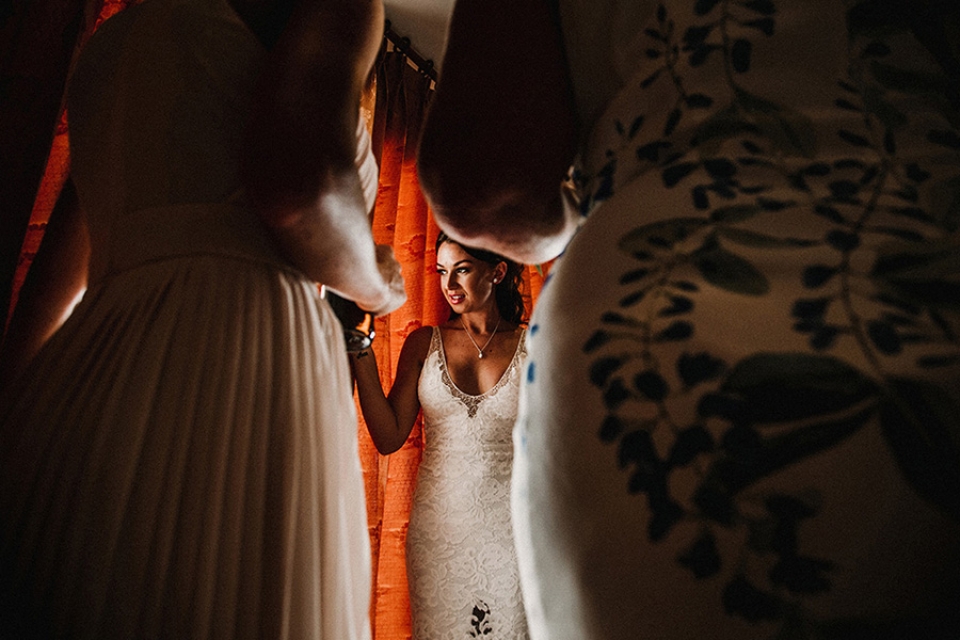 bride peaking through the curtains at her guests