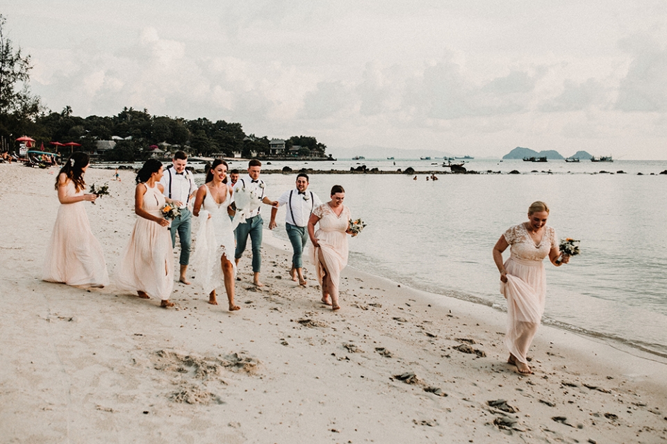 bridal party strolling on the beach