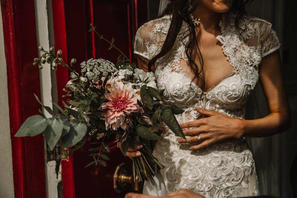 bride holding the flowers at a red door , talbot hotel wedding venue