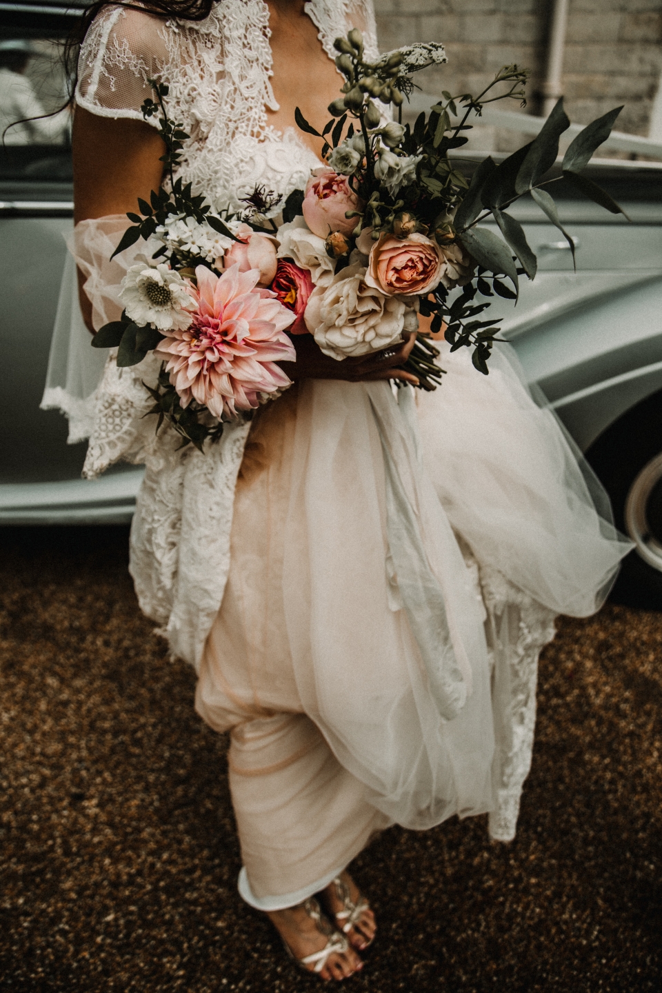 bride holding her flowers in front of her vintage bentley