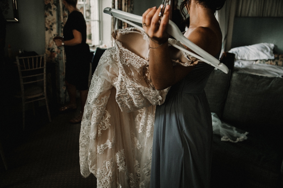 bridesmaids getting wedding dress ready for bride