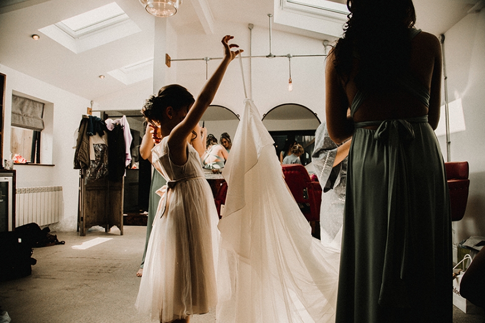 flower girl helping bride into dress