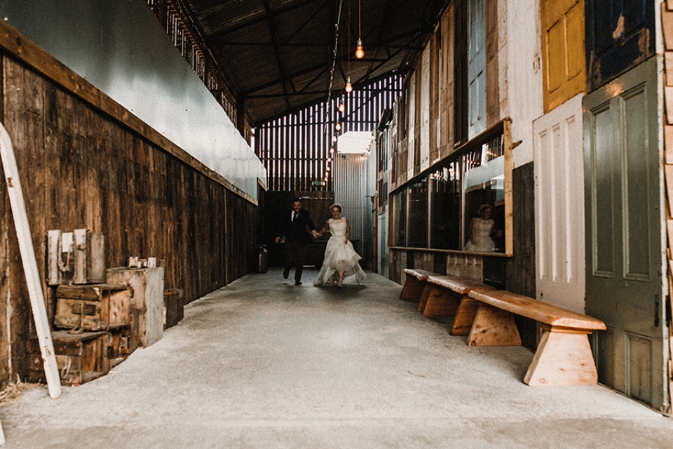 bride and groom giggling and running down the hall at owen house