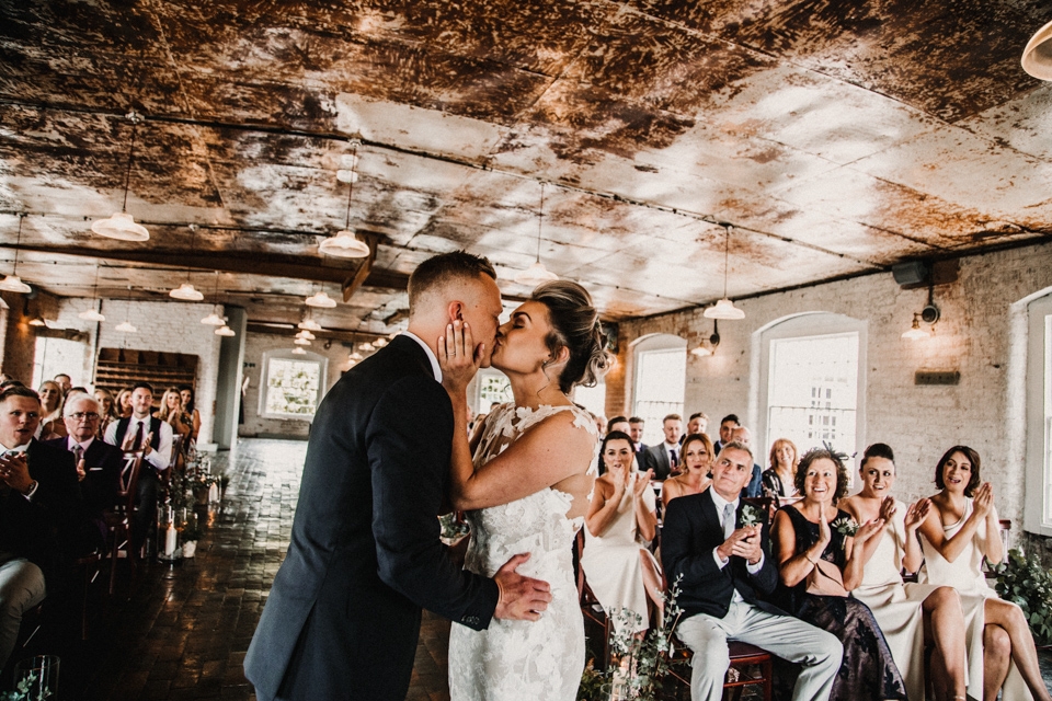 first kiss between bride and groom during the ceremony